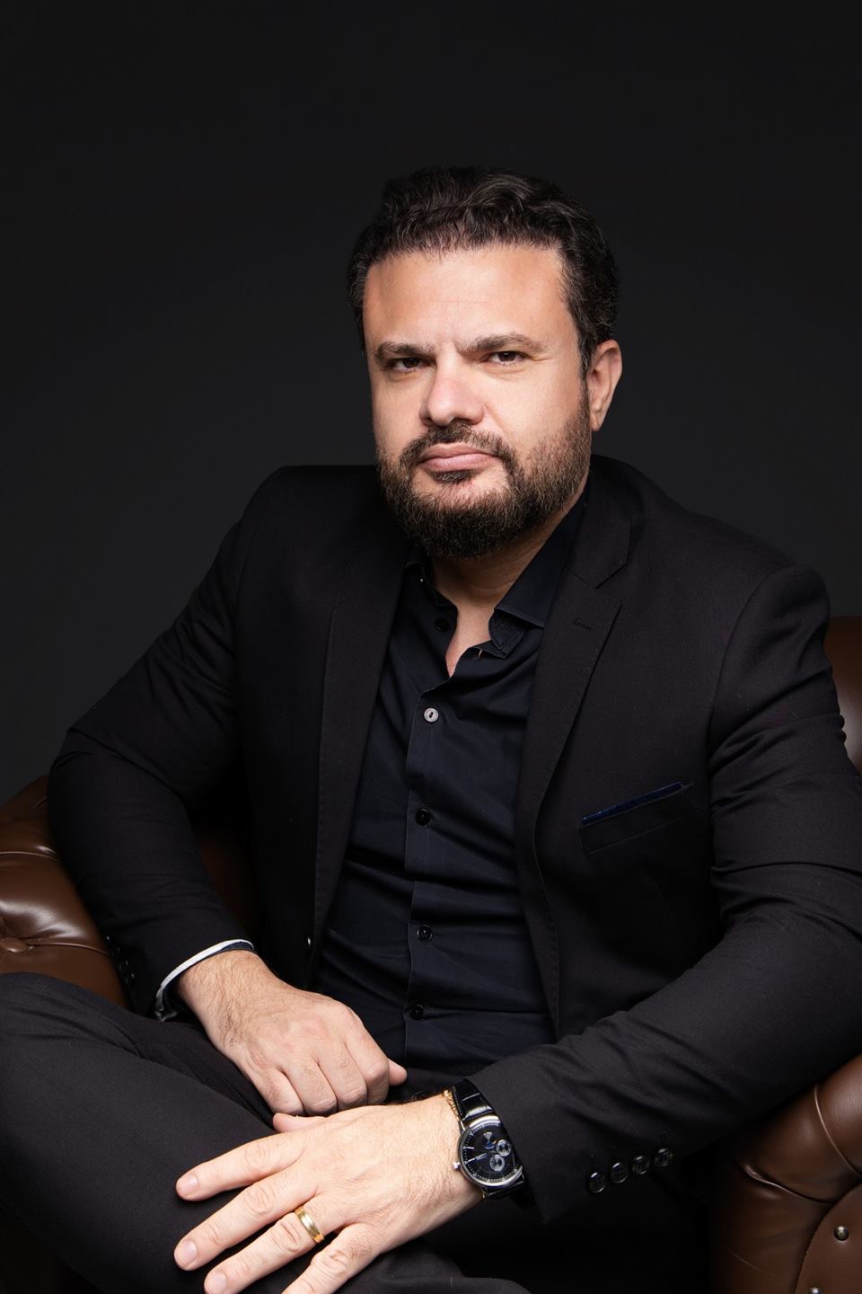 Fabrício Lima Silva sentado em uma poltrona, em traje casual